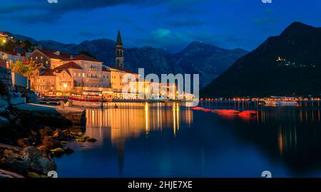 Una lunga esposizione tramonto vista panoramica della Baia di Kotor e luci nella cartolina perfetta città di Perast, Montenegro con le montagne sullo sfondo Foto Stock