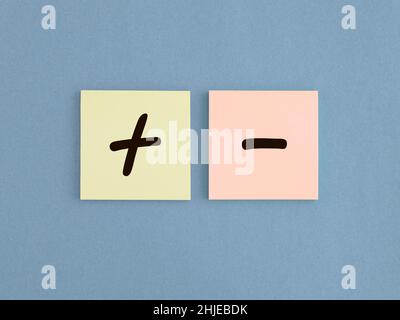 Segni più e meno sulla carta. Concetto di positivo e negativo, pro e contro. Confronto tra buono e cattivo. Foto Stock