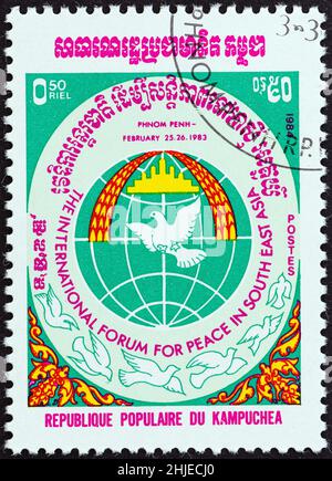 KAMPUCHEA - CIRCA 1984: Un francobollo stampato a Kampuchea pubblicato per la Pace Internazionale nel Forum Sud-Est asiatico, Phnom Penh mostra Doges e Globe. Foto Stock