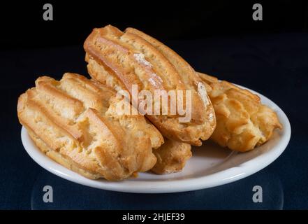 Dolci in un piatto bianco su sfondo nero. Primo piano con deliziosa delicatezza Foto Stock