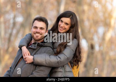 Giovane coppia innamorata abbraccia il parco e guarda la macchina fotografica Foto Stock