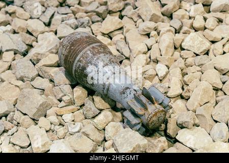 Una miniera di mortaio inesploso che giace sulle rocce. Eliminazione di conchiglie inesplose dopo una battaglia in guerra. Foto Stock