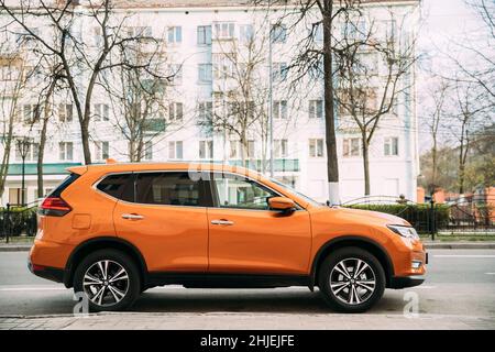 Orange Nissan X-Trail auto di terza generazione parcheggiata in strada. Vista laterale Foto Stock