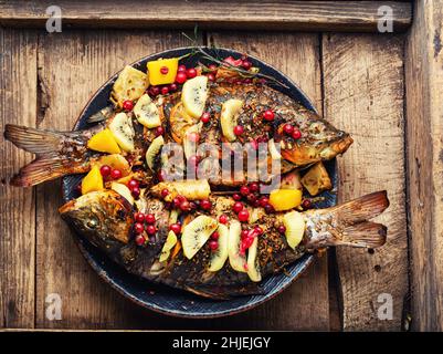 Pesce di fiume al forno con frutta, bacche e spezie. Carpa alla griglia, pesce Foto Stock