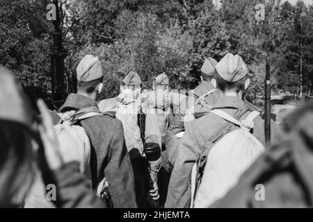 Re-enactor vestiti come soldati dell'esercito rosso sovietico russo della seconda guerra mondiale che marchano attraverso la foresta nel giorno d'autunno. Foto in bianco e nero. Soldato Foto Stock