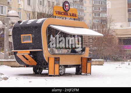 Caffè su ruote, in un ambiente urbano in inverno. Caffè caldo quando nevica. Caffetteria mobile, piccole aziende. Foto Stock