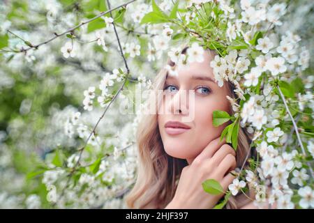 bella donna bionda vicino ciliegia fiore primo piano ritratto Foto Stock