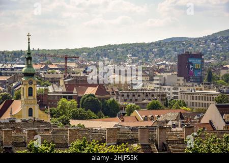 BUDAPEST, UNGHERIA - MAGGIO 2019: Vista su Budapest dalla collina di Gellert, Ungheria. Antiche case con tetti di tegole, maestosi palazzi e basiliche contro un c Foto Stock