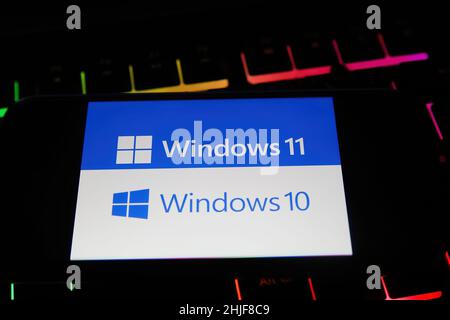 Viersen, Germania - Gennaio 9. 2022: Primo piano del telefono cellulare con la scritta del logo del sistema operativo Windows 10 e 11 sulla tastiera del computer Foto Stock