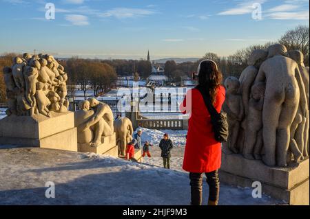 Lady in rosso scattando una foto del Parco delle sculture di Vigeland con la chiesa di Uranienborg in lontananza dal Monolith, Frogner Park, Oslo, Norvegia. Foto Stock