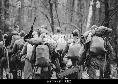 Re-enactor vestiti come soldati dell'esercito rosso sovietico russo della seconda guerra mondiale che marchano attraverso la foresta nel giorno d'autunno. Foto in bianco e nero. Soldato Foto Stock