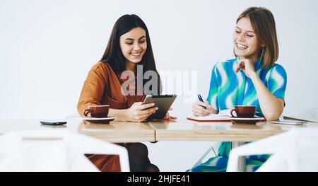 Allegro freelance femminile seduto al tavolo Foto Stock