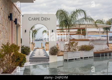 Side, Turchia - 22 gennaio 2022: Vetrina del ristorante Сarpe Diem con molti aiuole e palme sullo sfondo del Mar Mediterraneo Foto Stock
