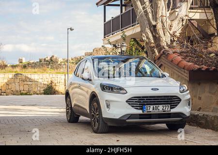 Side, Turchia - 22 gennaio 2022: White Ford Kuga è parcheggiata sulla strada in una giornata calda sullo sfondo di un centro storico laterale Foto Stock