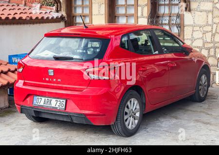 Side, Turchia - 22 gennaio 2022: Red Seat Ibiza è parcheggiata sulla strada in una giornata calda sullo sfondo di un centro storico laterale Foto Stock