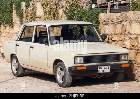 Side, Turchia - 22 gennaio 2022: Beige Tofas è parcheggiato sulla strada in una giornata calda sullo sfondo di un centro storico laterale Foto Stock