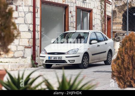 Side, Turchia - 22 gennaio 2022: White Ford Focus è parcheggiato sulla strada in una giornata calda sullo sfondo di un centro storico laterale Foto Stock