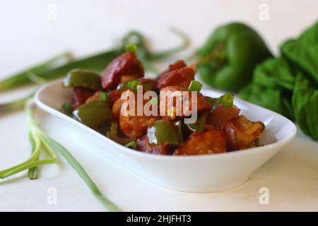 Manchurian di Idli. Un alimento di fusione Indo Cinese preparato con idlis, capsicum e cipolline di leftover. Preparato tagliando l'idlis rimasto in una piccola polvere Foto Stock