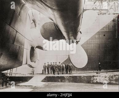 Una fotografia d'epoca dei lavoratori dei cantieri navali e dei propellori che hanno guidato RMS Titanic, la linea passeggeri britannica, prima del suo lancio nel 1911. Gestito dalla White Star Line, che affondò nell'Oceano Atlantico settentrionale il 15 aprile 1912 dopo aver colto un iceberg durante il suo primo viaggio da Southampton, Regno Unito, a New York City. Dei circa 2.224 passeggeri e equipaggio a bordo, più di 1.500 sono morti, il che ha reso il naufragio forse uno dei più letali per una sola nave fino a quel momento. Foto Stock