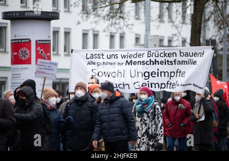 Friburgo, Germania. 29 gennaio 2022, bassa Sassonia, Osnabrück: I manifestanti passano un pilastro pubblicitario per la campagna di vaccinazione contro il virus della corona. I partecipanti si dimostrano contrari alla politica di Corona. Credit: dpa Picture Alliance/Alamy Live News Foto Stock