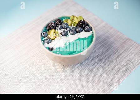 Sana colazione bacche, banana frullato ciotola con mirtilli e semi di chia, more, kiwi, noce di cocco delizioso mirtillo frullato ciotola. v Foto Stock