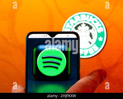 In questa illustrazione, il logo Spotify viene visualizzato sullo schermo di uno smartphone con il logo Starbucks sullo sfondo. (Foto di Igor Golovniov / SOPA Images/Sipa USA) Foto Stock