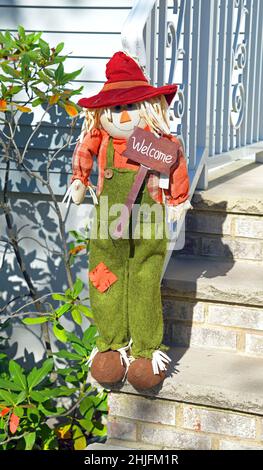 Sparecrow di benvenuto per la stagione autunnale, con cappello rosso e cartello di benvenuto. Foto Stock