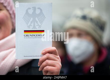 Friburgo, Germania. 29 gennaio 2022, bassa Sassonia, Osnabrück: Una copia della Legge fondamentale per la Repubblica federale di Germania dell'Agenzia federale per l'educazione civica è detenuta dal dimostratore. I partecipanti si dimostrano contrari alla politica di Corona. Credit: dpa Picture Alliance/Alamy Live News Foto Stock