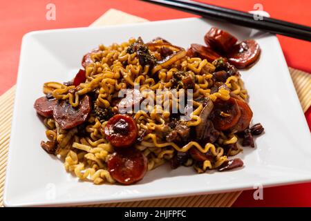 Goiânia, Goias, Brasile – 29 gennaio 2022: Una cena bianca con una porzione di yakisoba vegetale con salsa di soia. Yakisoba vegetariano. Foto Stock