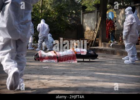 Guwahati, Assam, India. 29th Jan 2022. I membri della famiglia che indossano il kit PPE che eseguono gli ultimi riti di una persona che è morta per la malattia di coronavirus COVID-19, in un terreno di cremazione a Guwahati, Assam, India Sabato 29 gennaio 2022. L'India ha registrato 250 mila nuovi casi di coronavirus, inclusi i casi di Coronavirus Omicron, nelle ultime 24 ore, mentre 573 persone sono morte a causa dell'infezione. Credit: David Talukdar/Alamy Live News Credit: David Talukdar/Alamy Live News Foto Stock