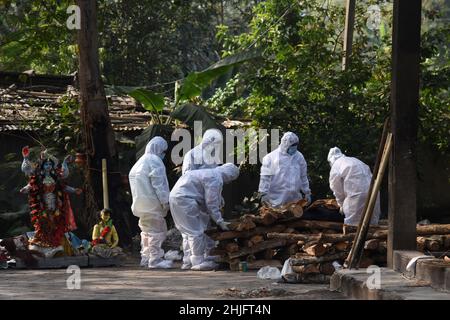 Guwahati, Assam, India. 29th Jan 2022. I membri della famiglia che indossano il kit PPE che eseguono gli ultimi riti di una persona che è morta per la malattia di coronavirus COVID-19, in un terreno di cremazione a Guwahati, Assam, India Sabato 29 gennaio 2022. L'India ha registrato 250 mila nuovi casi di coronavirus, inclusi i casi di Coronavirus Omicron, nelle ultime 24 ore, mentre 573 persone sono morte a causa dell'infezione. Credit: David Talukdar/Alamy Live News Credit: David Talukdar/Alamy Live News Foto Stock