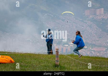 Belmira, Antioquia, Colombia - Novembre 20 2021: Le donne che scattano foto e filmate dei Paragliatori che decolgono e volano tra le montagne Foto Stock