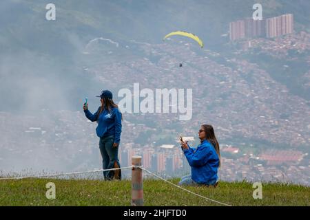 Belmira, Antioquia, Colombia - Novembre 20 2021: Le donne che scattano foto e filmate dei Paragliatori che decolgono e volano tra le montagne Foto Stock