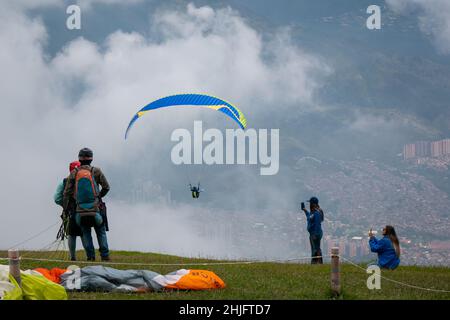 Belmira, Antioquia, Colombia - Novembre 20 2021: Le donne che scattano foto e filmate dei Paragliatori che decolgono e volano tra le montagne Foto Stock