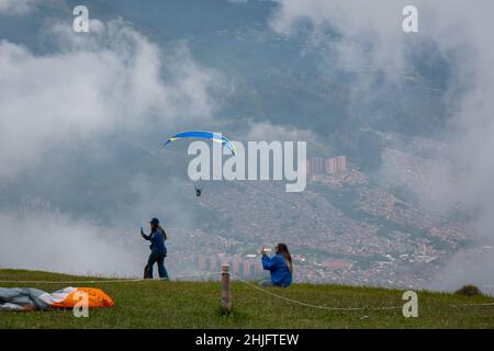 Belmira, Antioquia, Colombia - Novembre 20 2021: Le donne che scattano foto e filmate dei Paragliatori che decolgono e volano tra le montagne Foto Stock