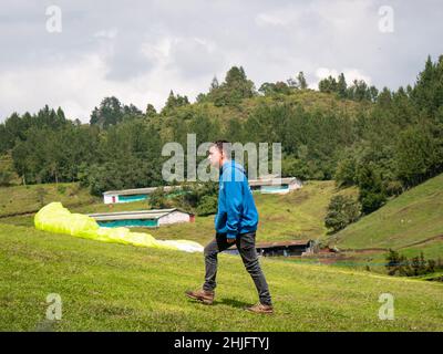 Belmira, Antioquia, Colombia - Novembre 20 2021: Un uomo marrone in un pullover blu cammina sul campo Foto Stock