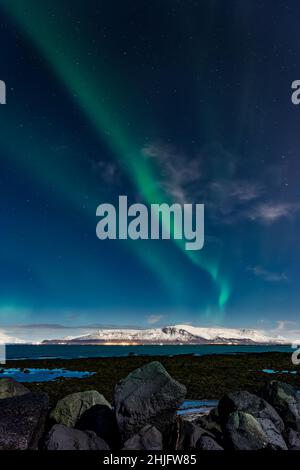 L'aurora boreale sopra il Monte Esja innevato nella capitale islandese, Reykjavic. Foto Stock