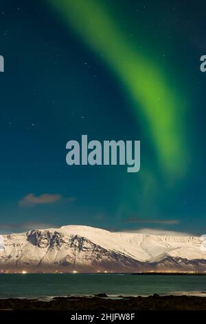 L'aurora boreale sopra il Monte Esja innevato nella capitale islandese, Reykjavic. Foto Stock