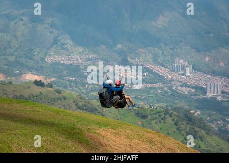 Belmira, Antioquia, Colombia - Novembre 20 2021: Uomini parapendio vicino alla montagna Verde, con una vista della città di Medellin Foto Stock