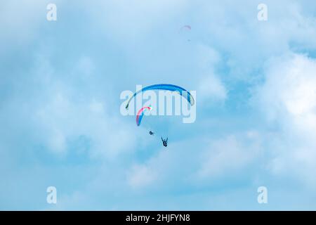 Belmira, Antioquia, Colombia - Novembre 20 2021: Parapendio blu e rosa, volo su sfondo blu pieno di nuvole Foto Stock