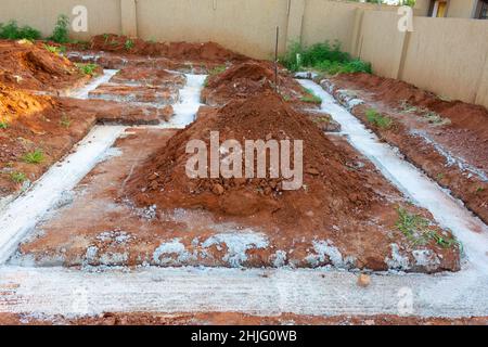 Trincee riempite di cemento delle fondamenta di un edificio che sta per essere costruito. Foto Stock