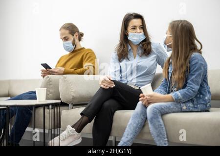 Persone sedute nella sala della clinica, in attesa di un appuntamento Foto Stock