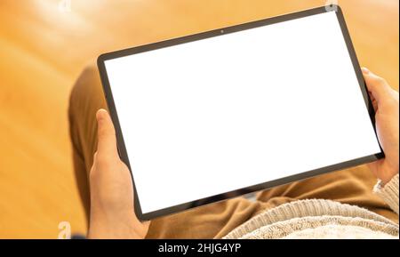 Schermo del tablet digitale vuoto. Uomo che lavora a casa, tiene il dispositivo sulla gamba, display vuoto bianco, spazio di copia Foto Stock