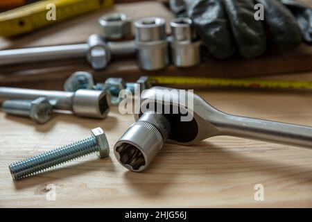 Chiave dinamometrica, attrezzatura con cricchetti reversibili su fondo in legno. Attrezzo manuale per serrare la vite e il dado. Tavolo da officina, vista da primo piano Foto Stock