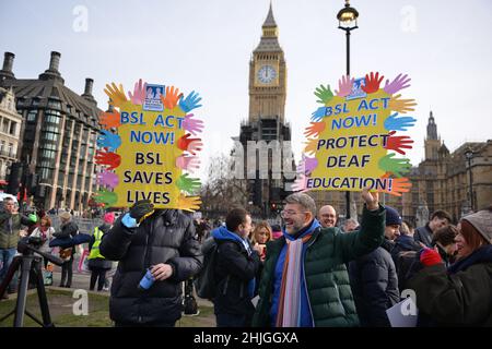 I manifestanti hanno visto tenere cartelli che esprimevano il loro parere durante la dimostrazione. Il linguaggio dei segni britannico e la comunità dei sordi si sono radunati di fronte al Parlamento britannico a sostegno della legge BSL (British Sign Language) che riconosce la lingua dei segni come lingua ufficiale del Regno Unito. Foto Stock