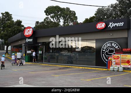 I clienti che entrano in un minimarket IGA Xpress, collegato a una stazione di servizio BP, nella periferia di Melbourne Foto Stock