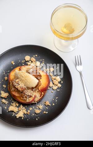 Cobbler alla pesca con panna coagulata e noci pecan candite Foto Stock