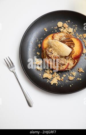 Cobbler alla pesca con panna coagulata e noci pecan candite Foto Stock