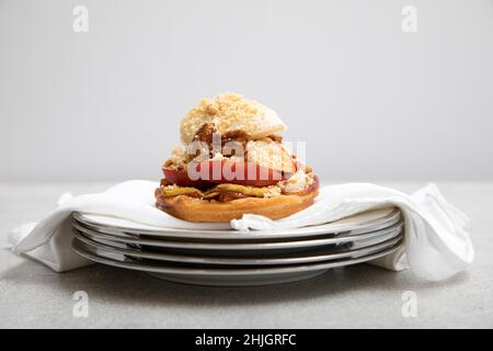 Cobbler alla pesca con panna coagulata e noci pecan candite Foto Stock