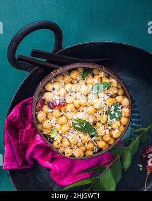 Insalata di ceci sudindiana guarnita con cocco, foglie di curry e peperoncino rosso secco Foto Stock